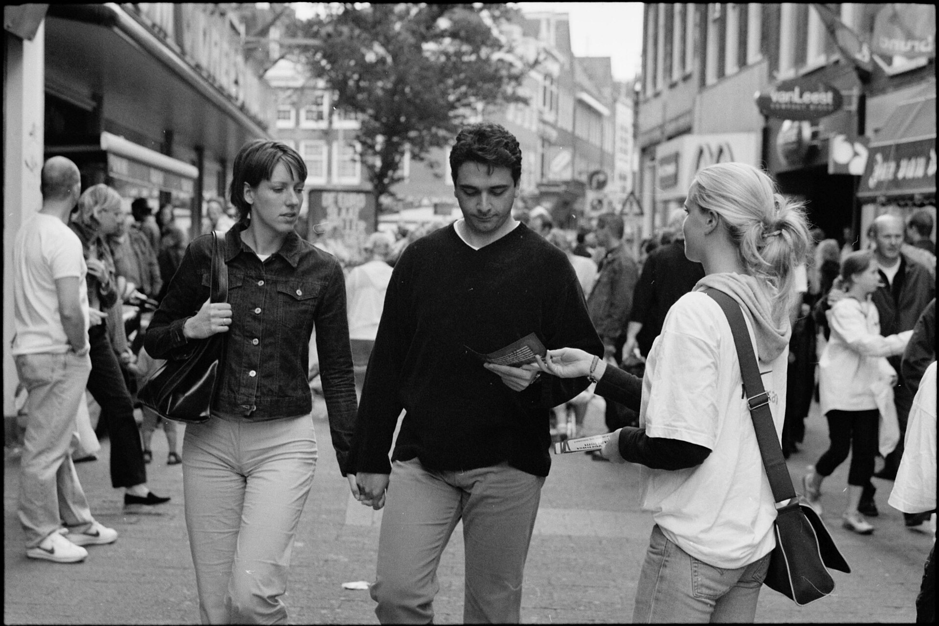 Mensen delen een flyer uit op straat in Haarlem, juni 2001.