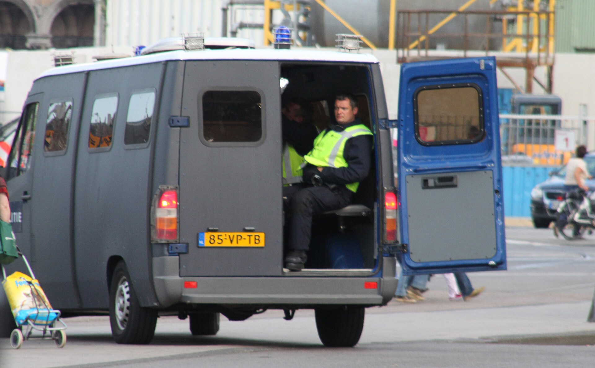 Een voertuig van de Mobiele Eenheid met een agent erbij, gefotografeerd in Amsterdam.